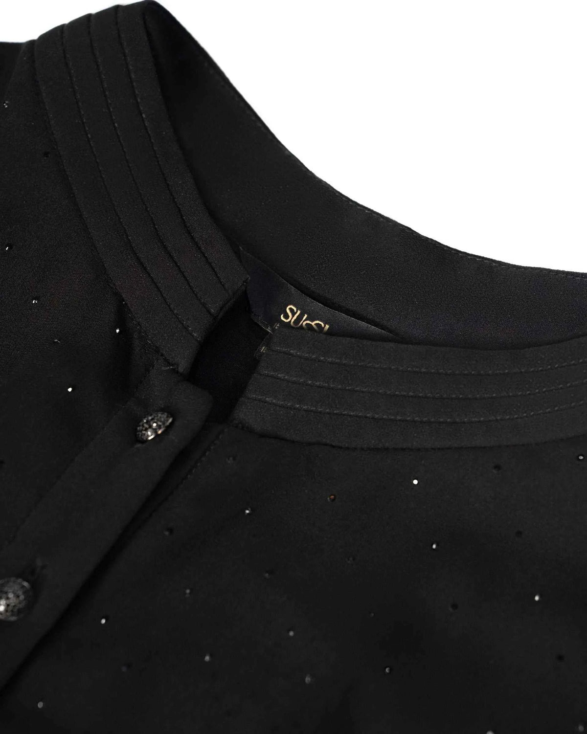 Narrow folds follow the upright neckline beside the front fastening.