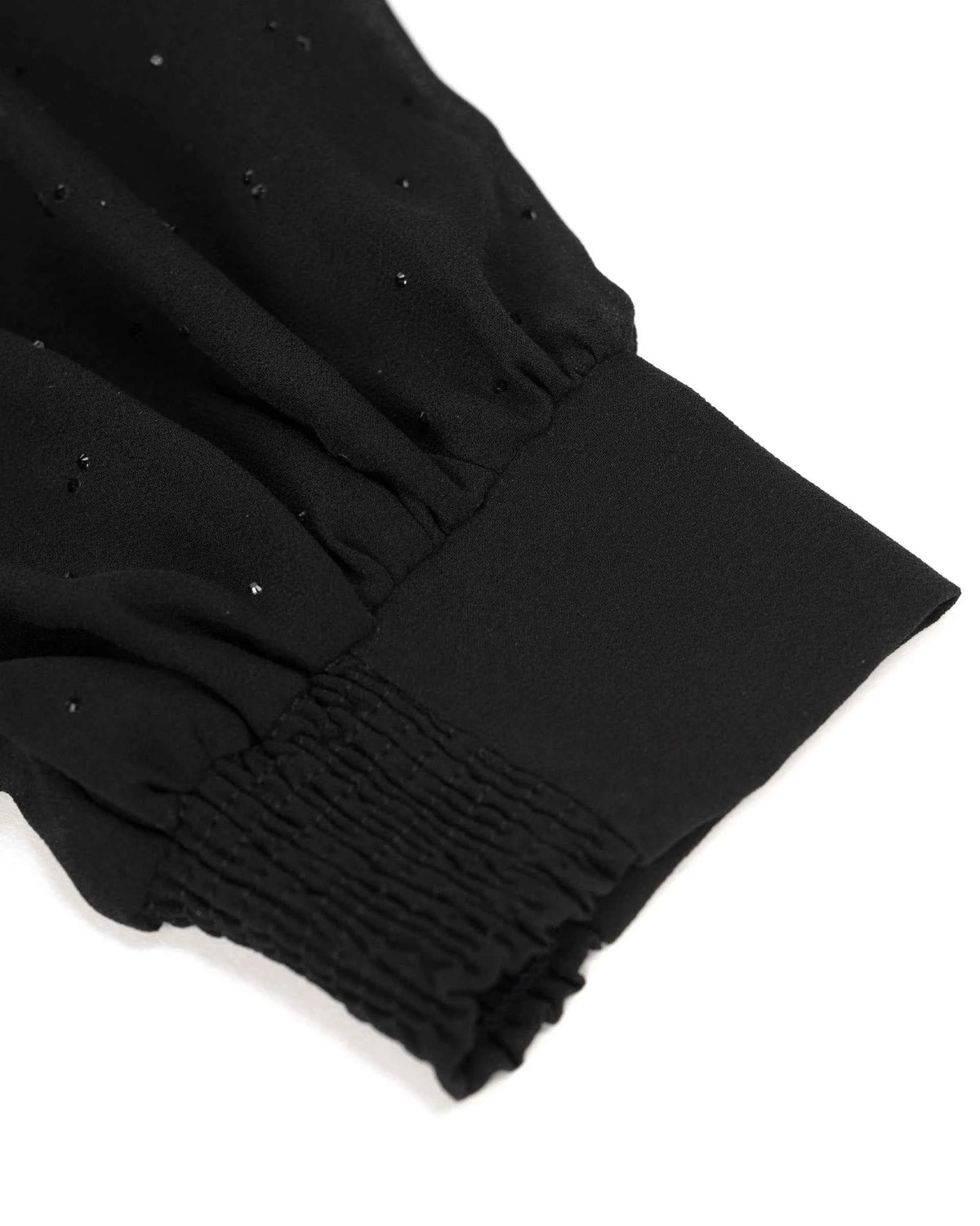 The sleeve gathers into a closely textured cuff, narrowing the fuller fabric above.