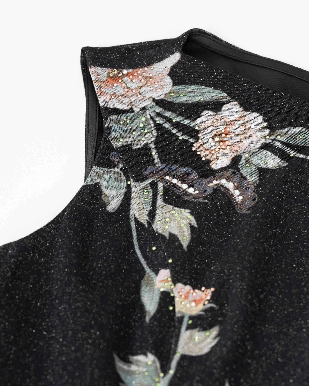 The floral embroidery continues towards the shoulder and upper edge, linking the neckline with the longer branches below.