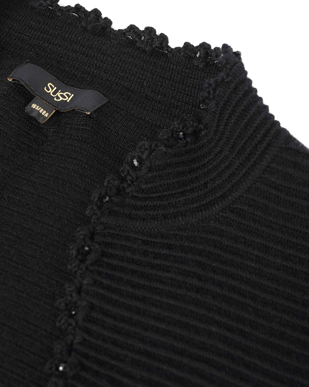 Rounded decorative details follow the edge of the ribbed neckline, creating a subtle pattern against black.