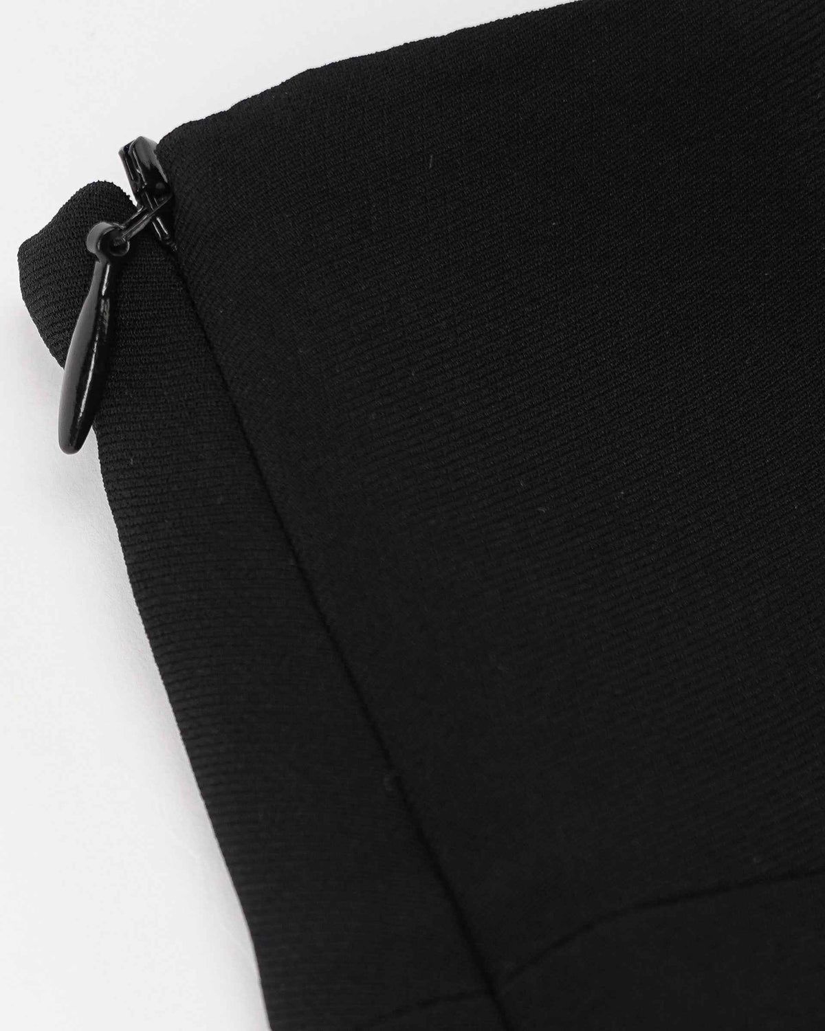 A dark fastening sits beside the waist seam, blending into the black fabric.