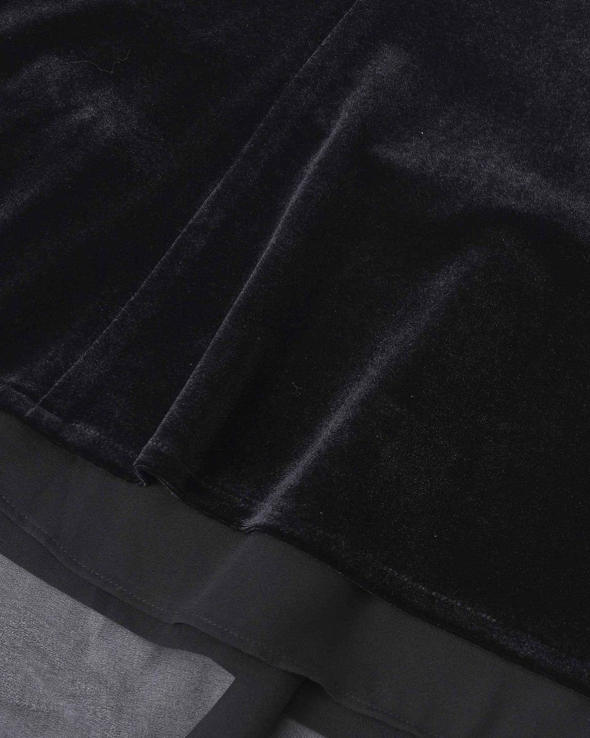 A sheer layer extends beneath the dark skirt, revealing a light, transparent border.