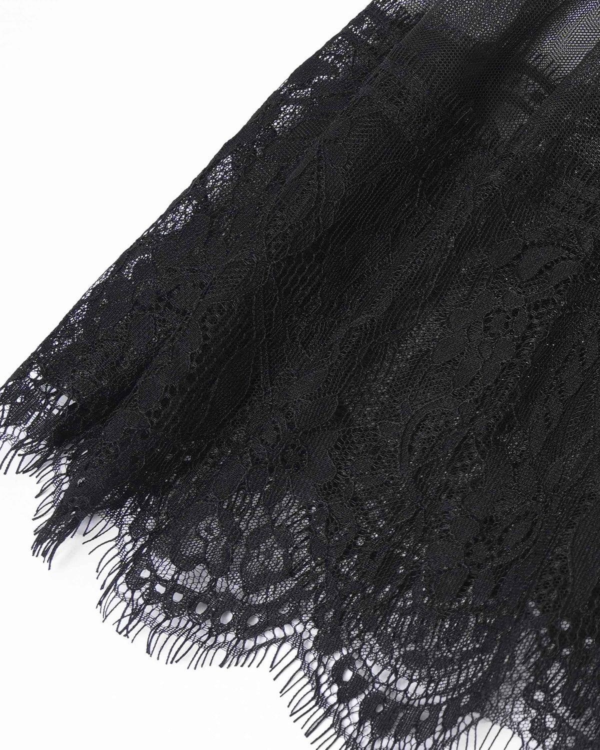 The close-up reveals a lace border with an intricate floral pattern and fine, fringed edges.