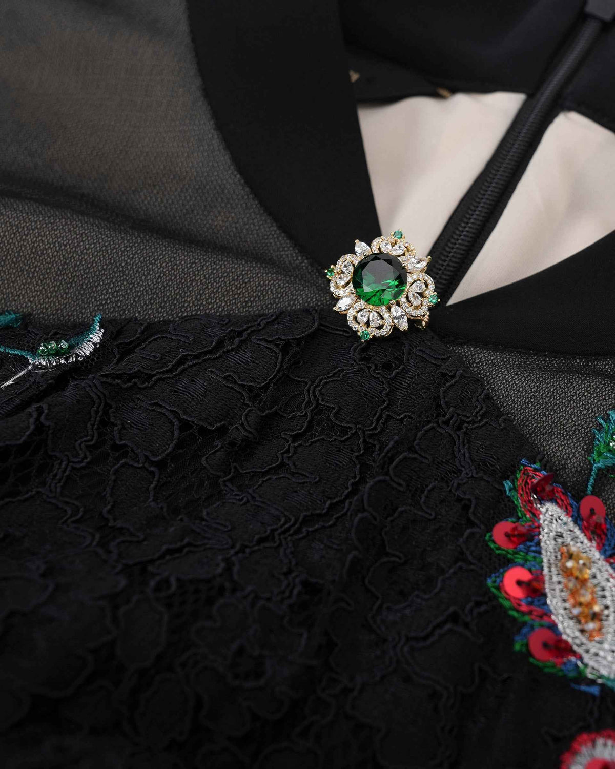 A green-centred ornament sits where the collar meets a small opening above the bodice.