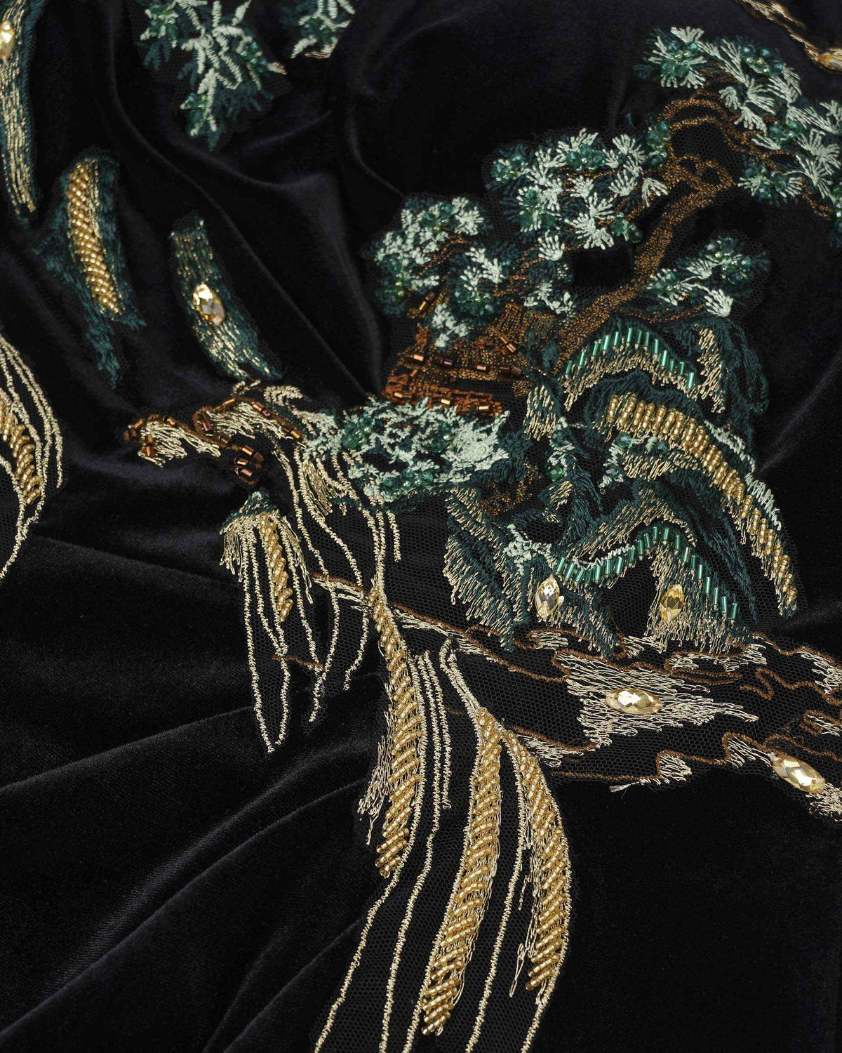 Trees, rocks, and flowing gold-toned lines form a landscape across the dark fabric.