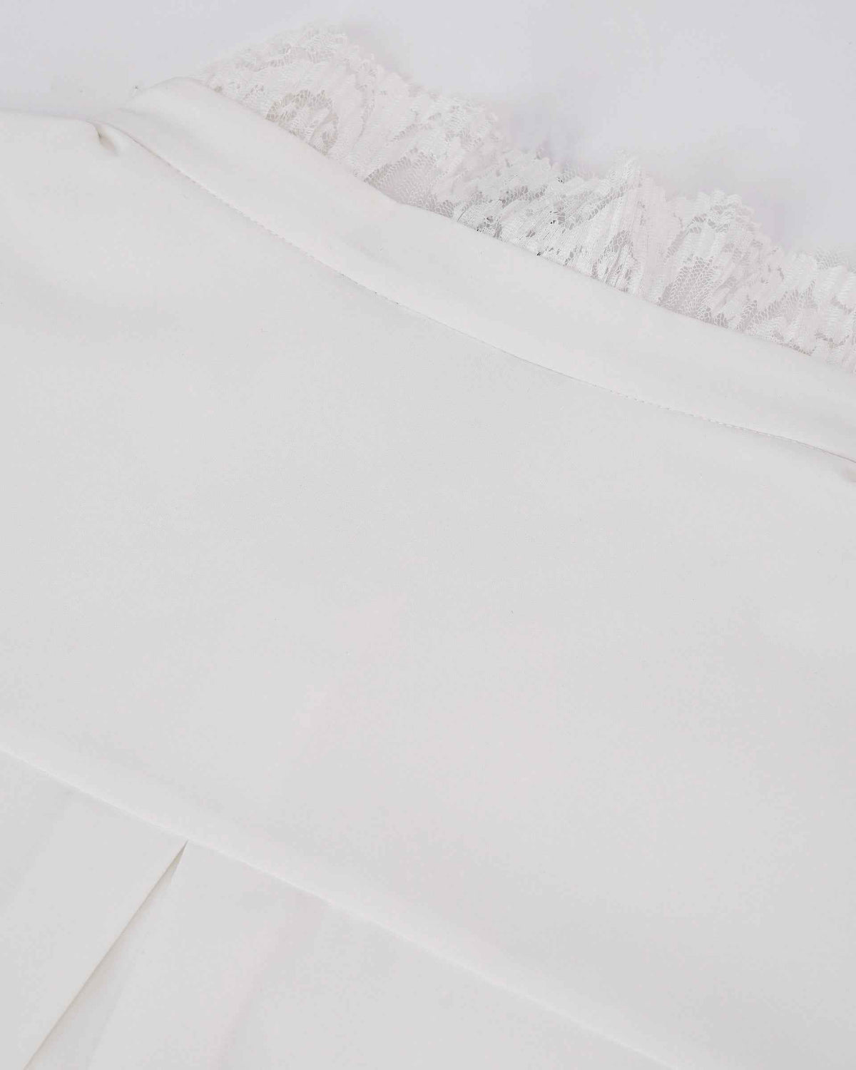A smooth pale layer sits beside the more intricate lace, revealing a contrast in texture.
