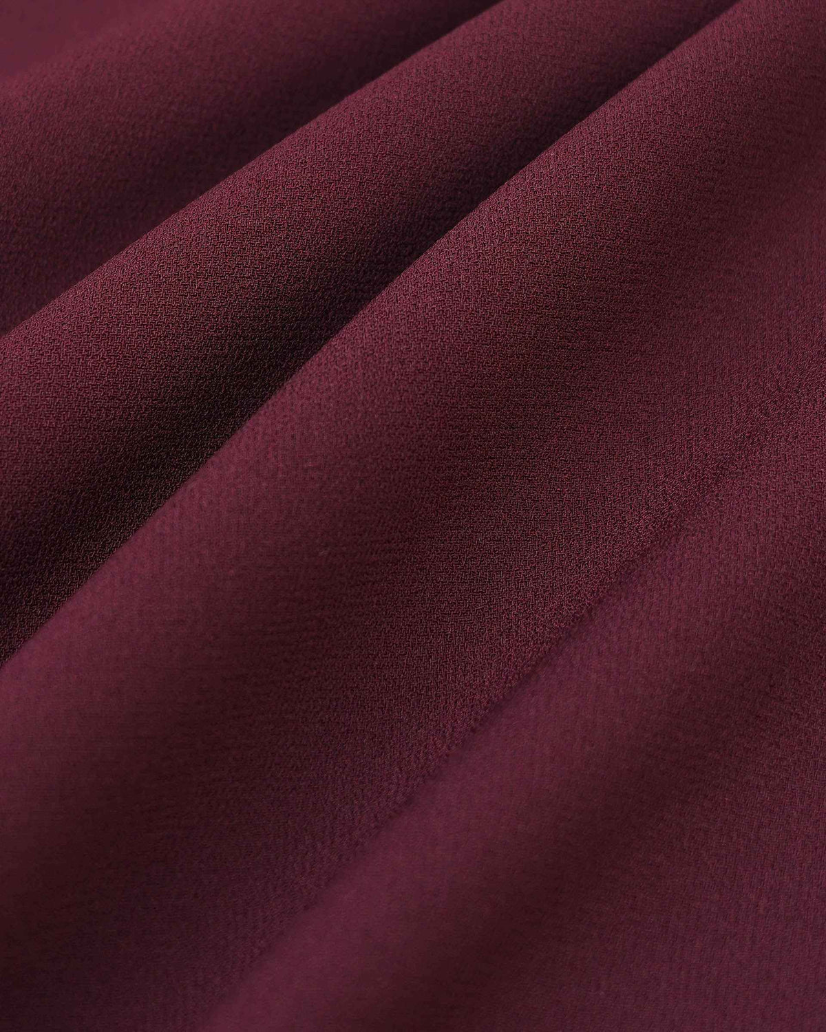 Broad folds create alternating bands of light and shadow across the burgundy surface.