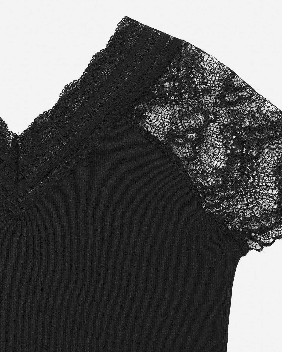 Floral lace forms a transparent sleeve beside the opaque black knit.