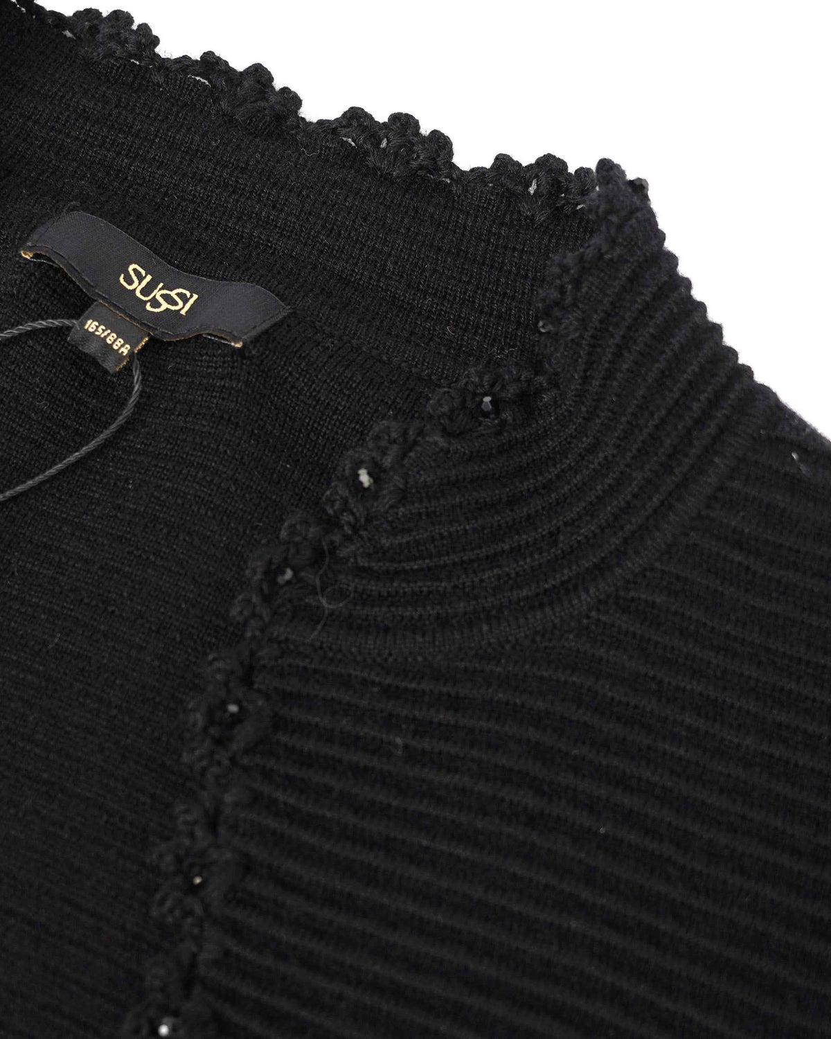 Small decorative accents follow the ribbed neckline, bringing a gentle sparkle to the black knit.