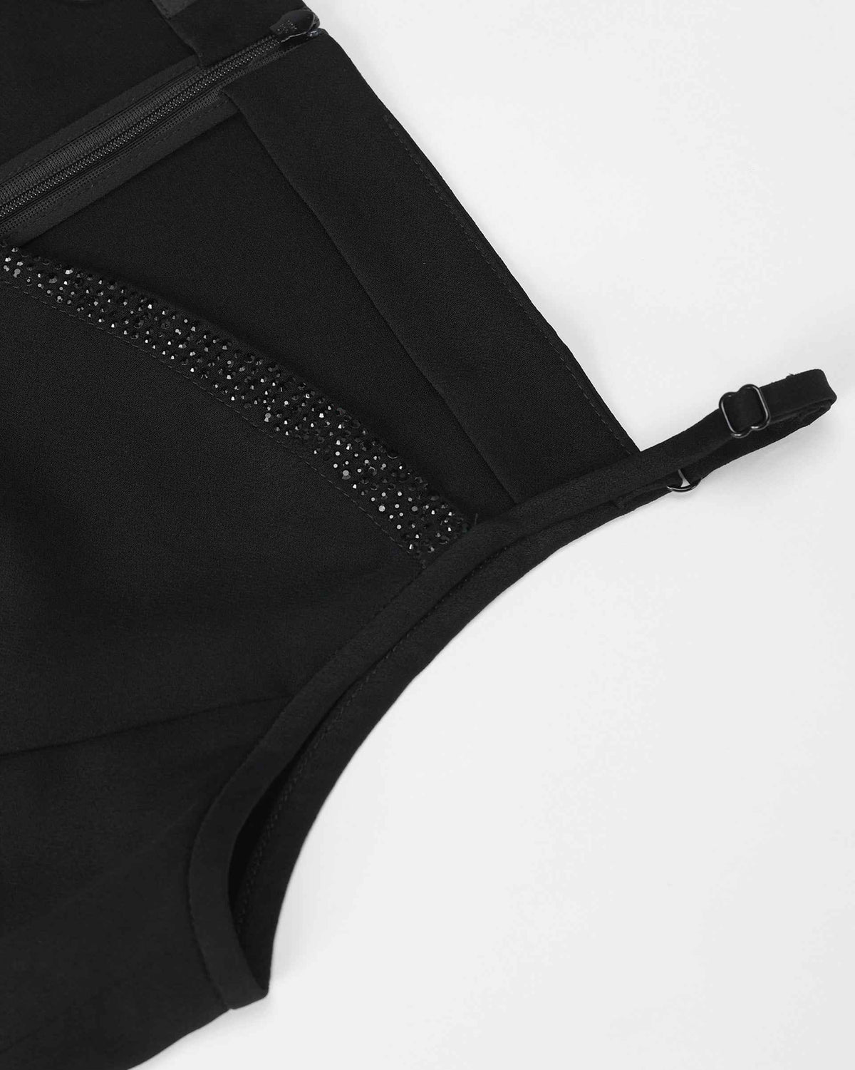 A narrow shoulder strap meets the embellished upper edge, with a small adjuster visible along its length.