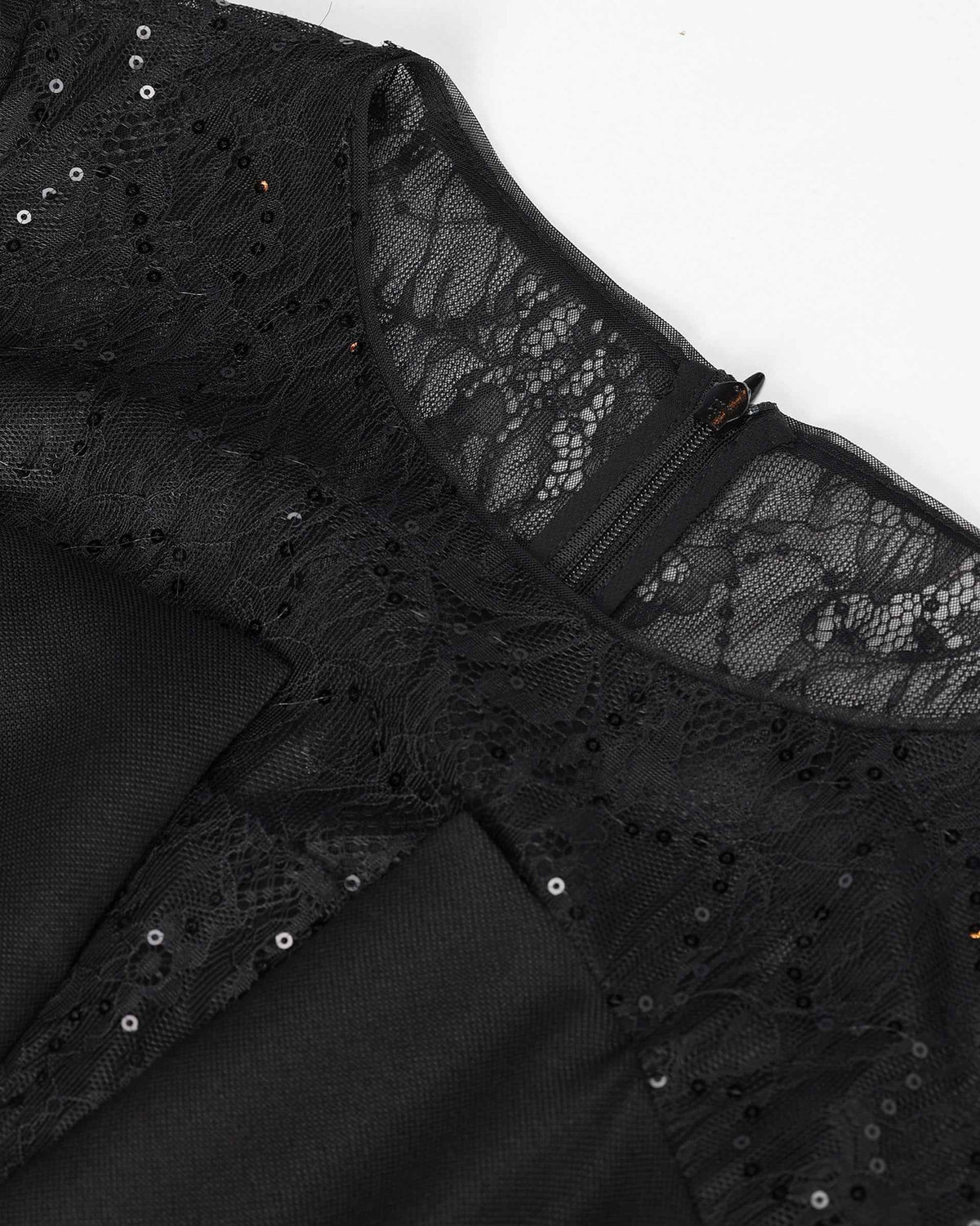 Transparent lace spans the upper section beside the opaque black body, with small reflective details catching light.