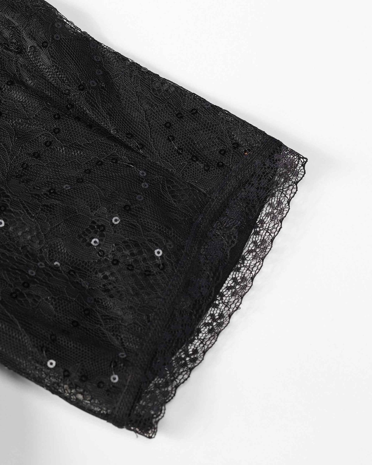 The lace sleeve reveals floral shapes within its transparent ground and a narrow decorative edge.