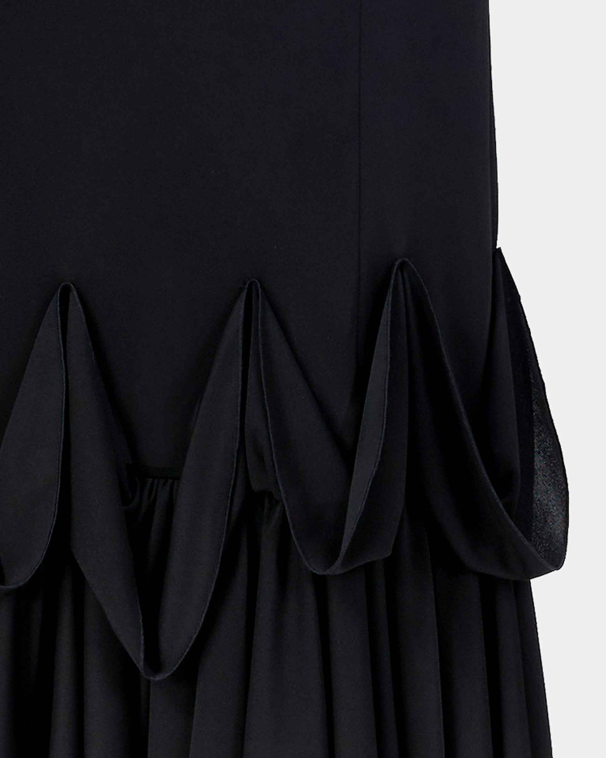 Curved layers open out at the skirt's lower edge, creating a fuller finish beneath its narrow body.