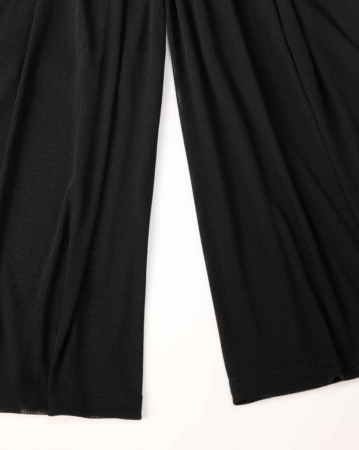 The fabric falls into long folds through the wide leg, creating a generous lower silhouette.