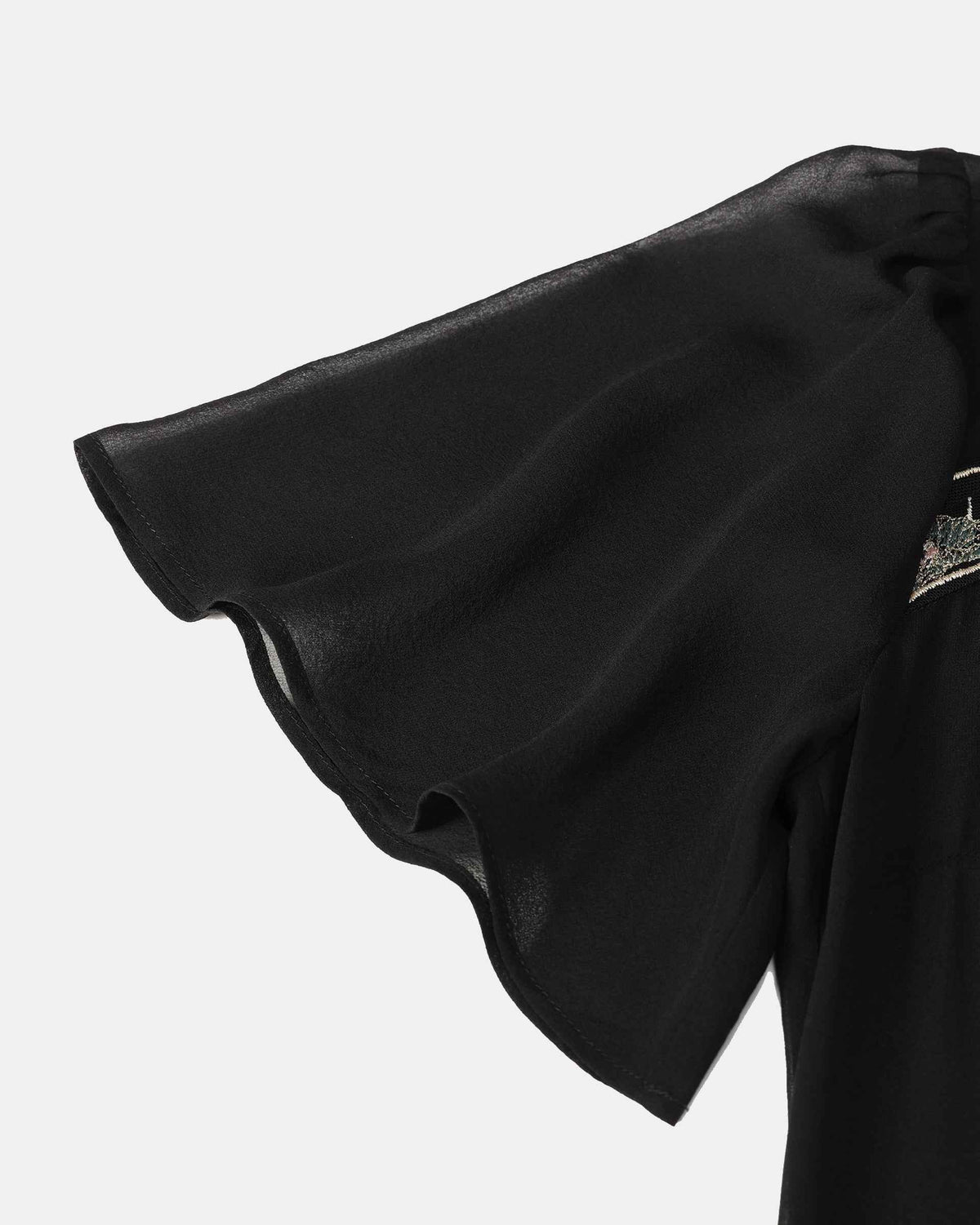 The short sleeve opens into a softly flared edge, with fine transparent fabric visible against the darker body.