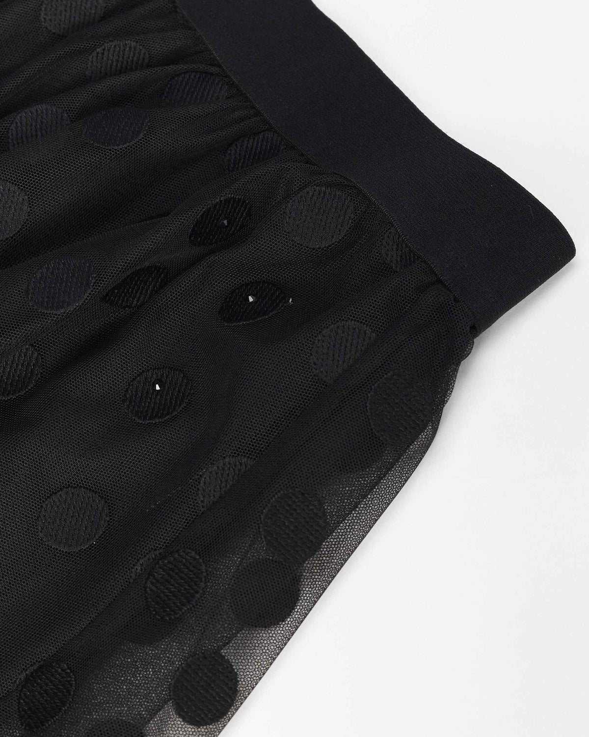 The waistband gathers the skirt into fine folds that open below the hip.