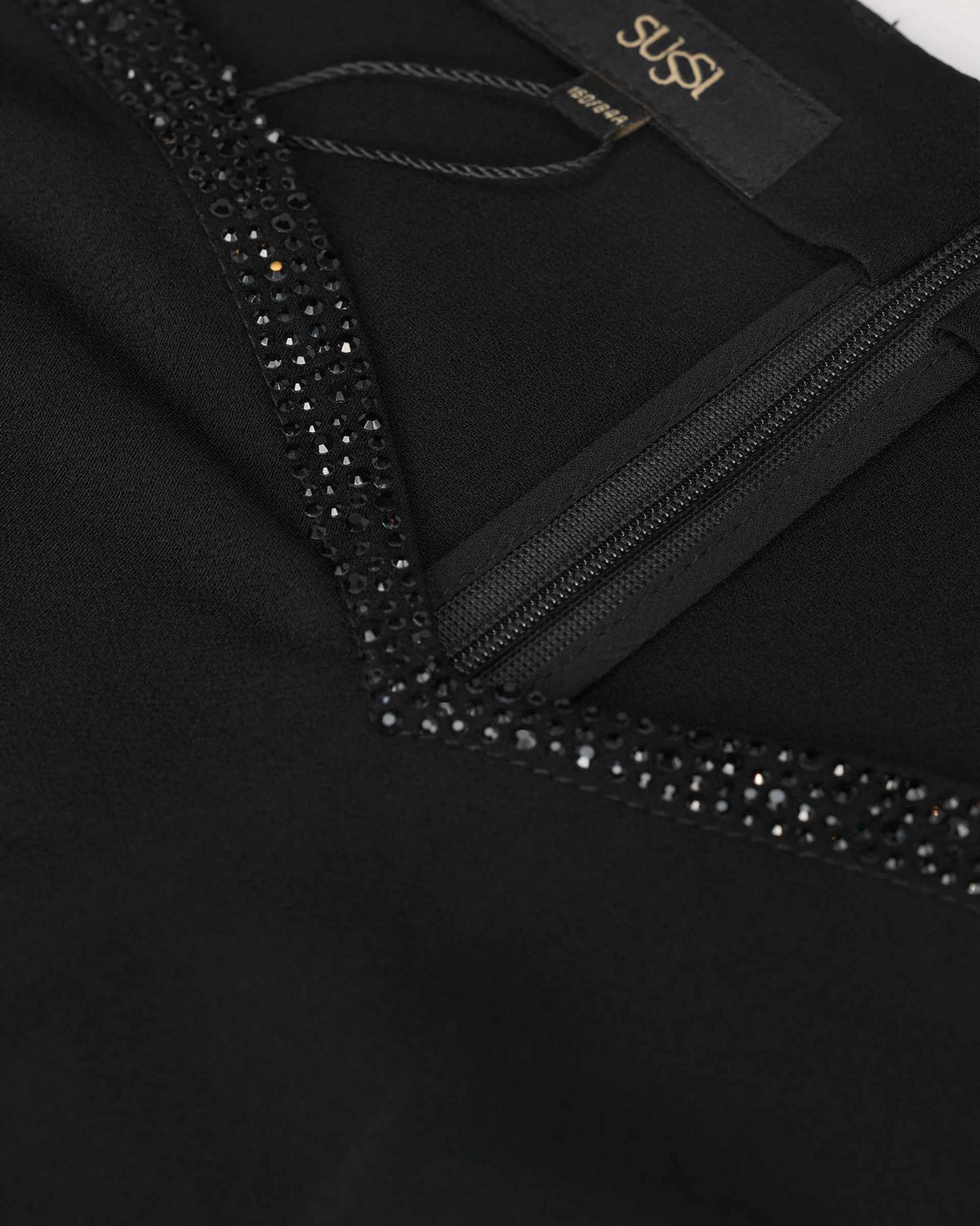 Tiny dark crystals follow the neckline beside a narrow transparent band.