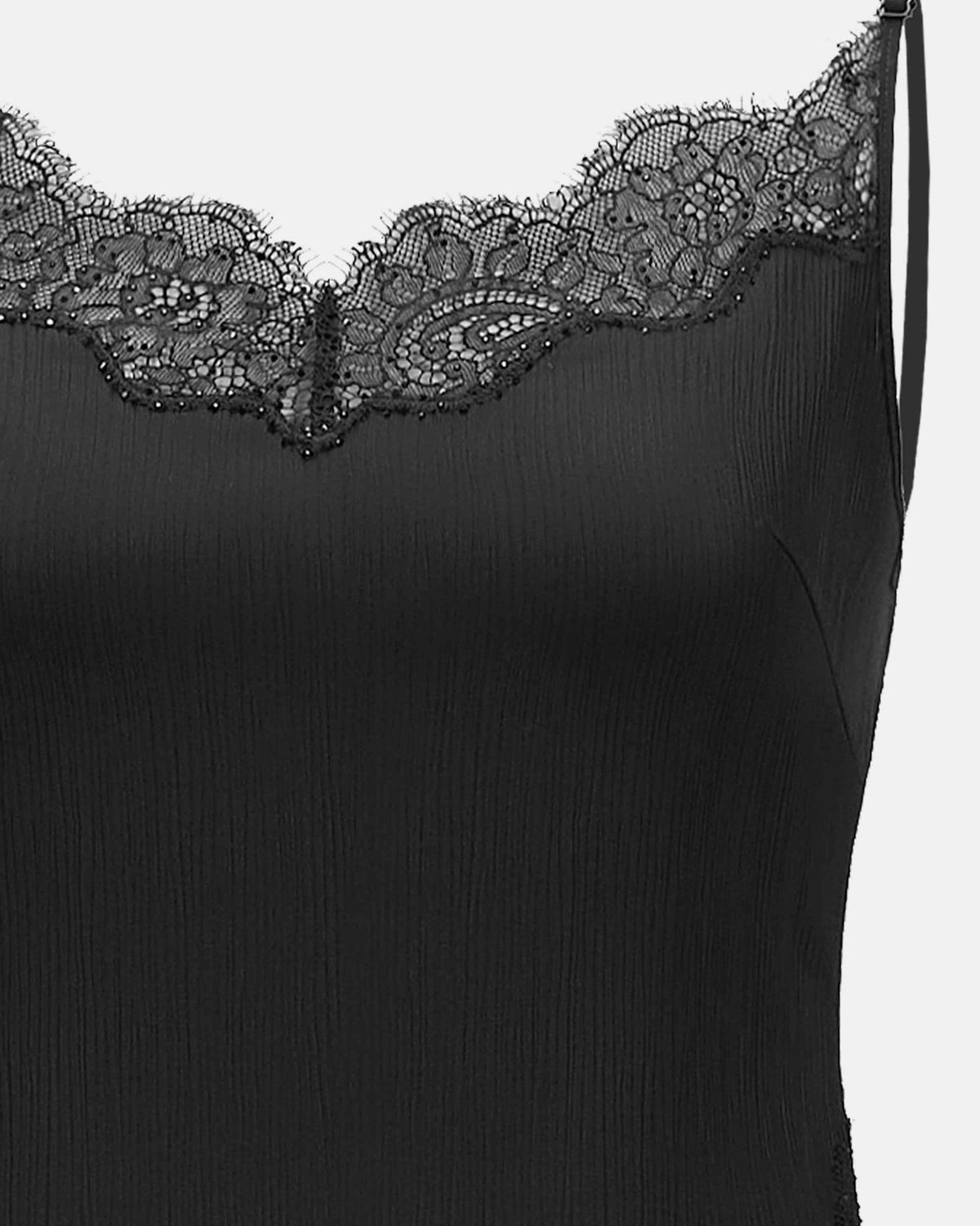 Floral lace follows the camisole's upper edge beneath fine shoulder straps.