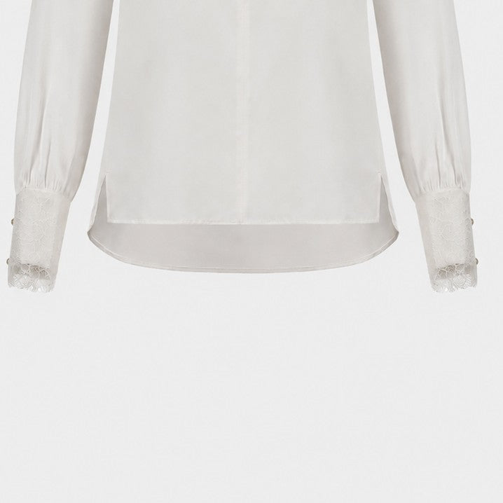 A light outer layer extends below the body of the ivory blouse, creating a transparent border.
