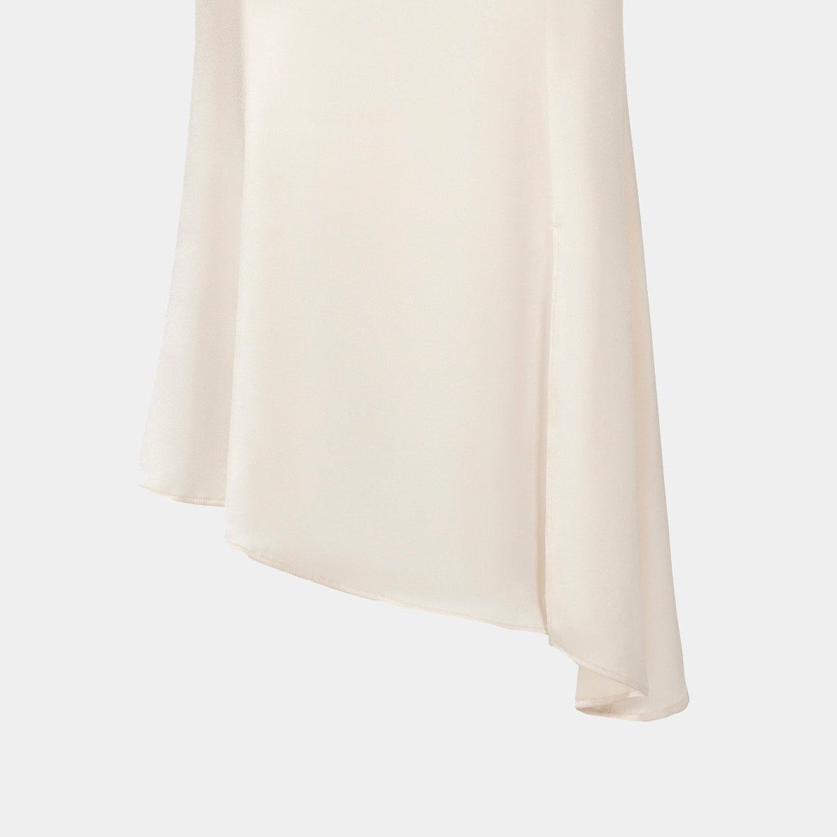 The skirt widens toward an angled hem, creating an uneven lower line against its smooth ivory body.