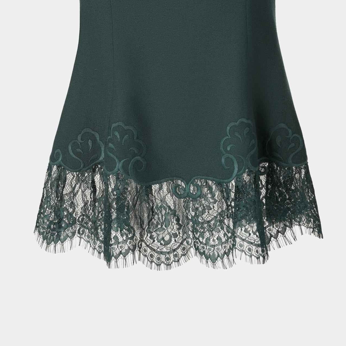 Dark floral lace extends below the green skirt, creating a transparent lower edge.