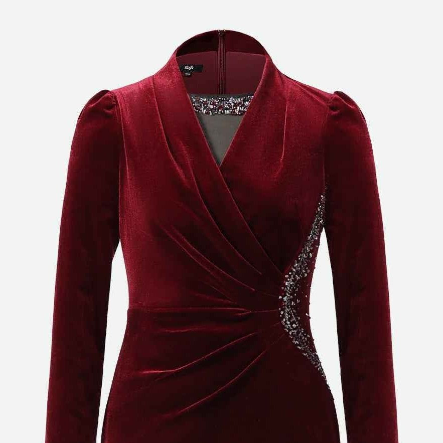 The burgundy velvet gathers across the waist beneath a shaped neckline, producing lighter folds against deeper shadows.