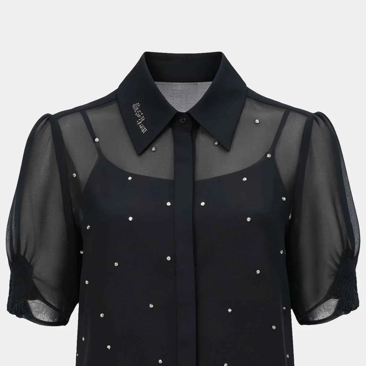The pointed collar and central front line bring structure to the upper section beside transparent shoulders and sleeves.